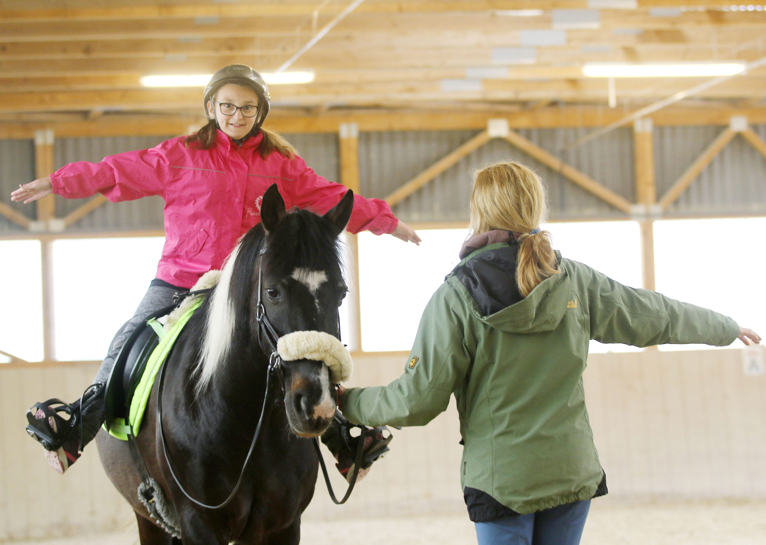 Kind auf Pferd mit Reitlehrerin